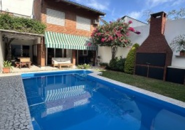 CASA AL FRENTE DESARROLLADA EN 2 PLANTAS 4/5 DORMITORIOS CON PISCINA PARRILLERO COCHERA PARA 2 VEHICULOS 